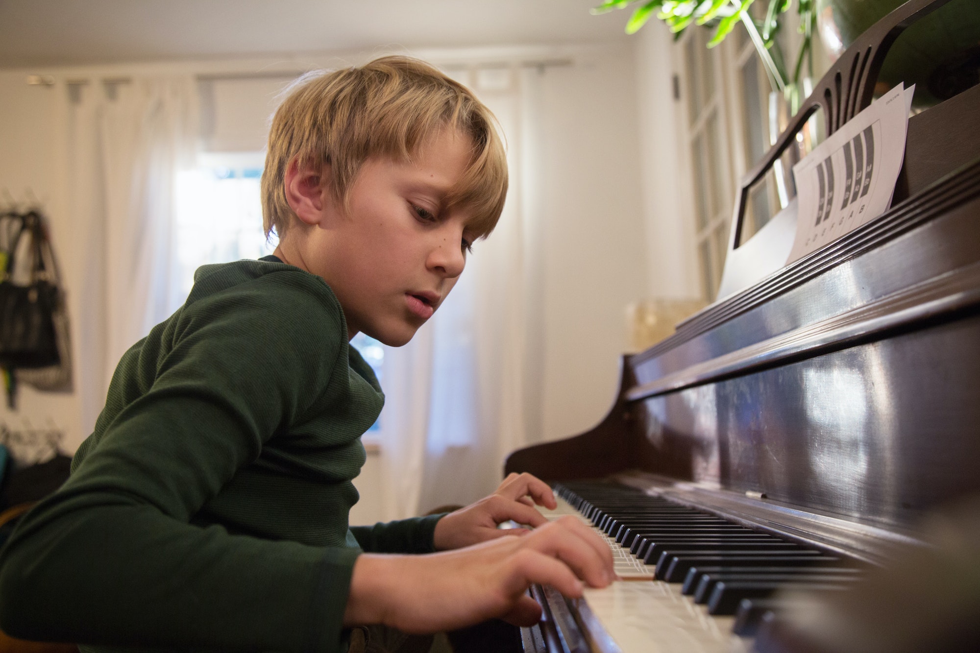 Boy playing piano in living room